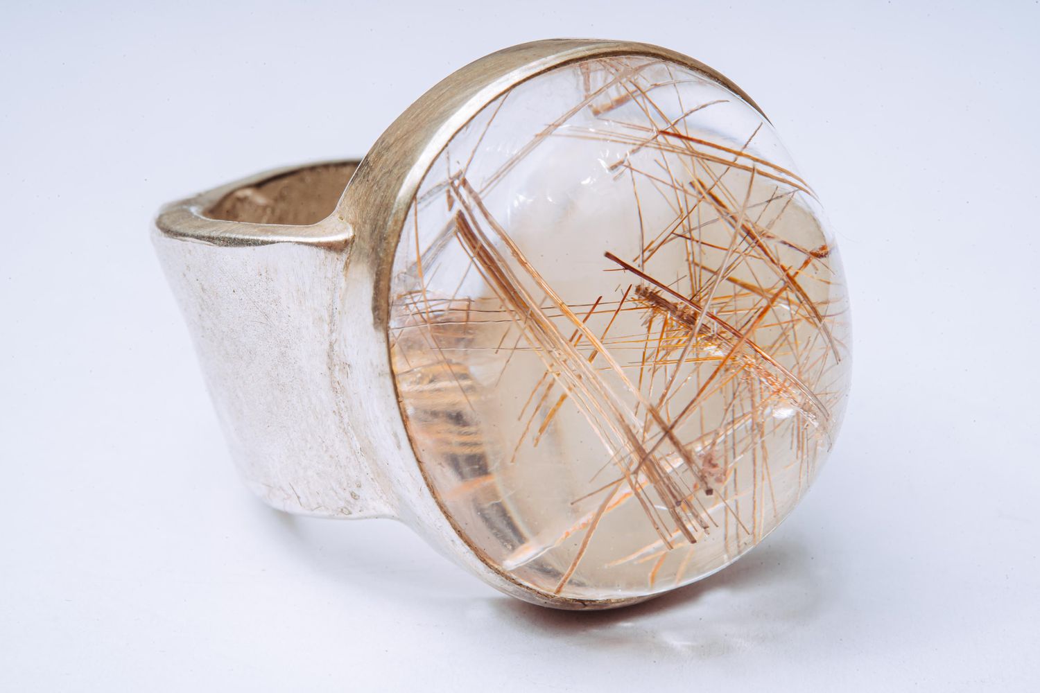 Rutilquarz (Bergkristall mit nadeligen Einschlüssen aus Rutil) auf einem Ring aus 925er Silber und Hautabdruck innen